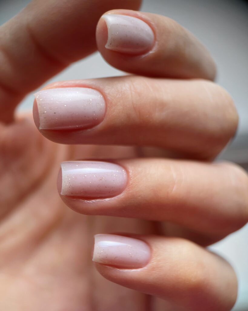 close up of a female with carefully manicured pastel pink fingernails